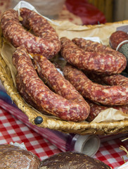 Freshly prepared raw sausage in basket on stall