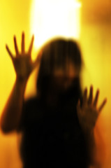 Horror woman behind the matte glass. Blurry hand and body figure