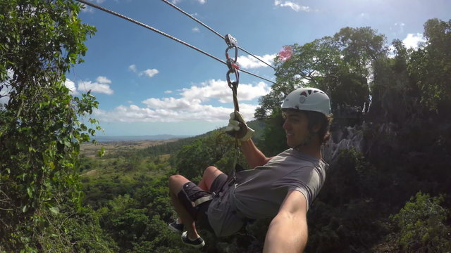 POV Young Happy Man Zip Lining In Tropical Jungle