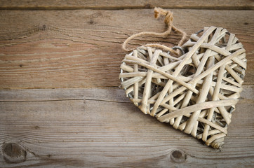 wicker heart handmade  lying on a wooden base.top view