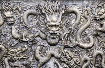 Ancient bronze dragons carving in the ancient Dragon King Temple along Yangtze River,China. Foreign text means King. - 100861928