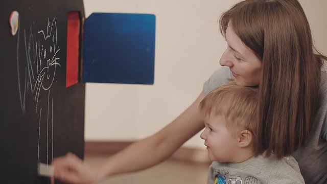 Mother with her son painting at home. 