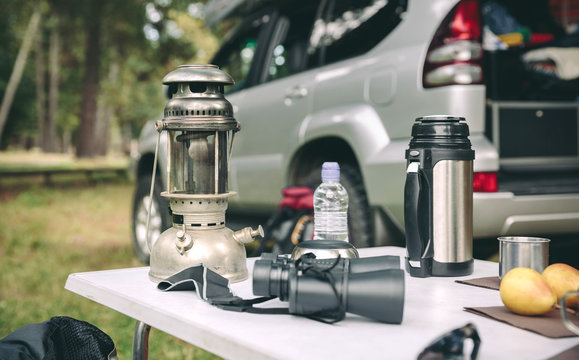 Oil Lamp, Thermos And Binoculars Over Camping Table