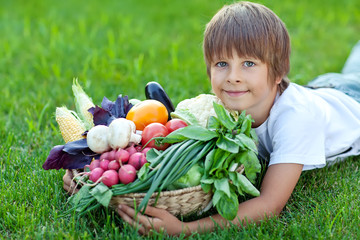 Happy little boy with fresh vegetables 