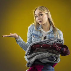 Girl with a bunch of clothes. The girl decides what to wear