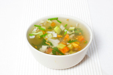 chopped soup ingredients: carrots, onions and celery cooking in a stainless steel pot
