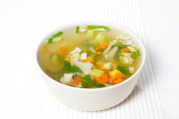 chopped soup ingredients: carrots, onions and celery cooking in a stainless steel pot