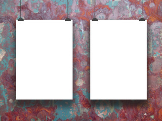 Close-up of two hanged paper sheets with clips on rusty metal background