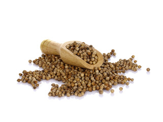 coriander seeds in a woodenscoop on white background