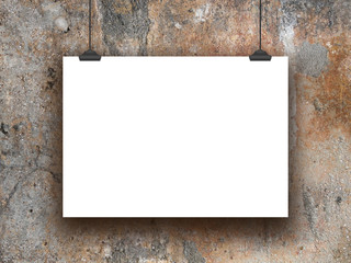 Close-up of one horizontal hanged paper sheet frame with clips on weathered wall background