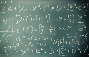 side view of math formulas and calculation written over chalkboard. selective focus.
