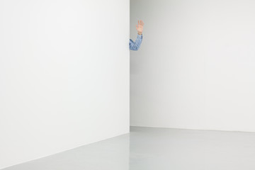 White walls corner with male hand waving