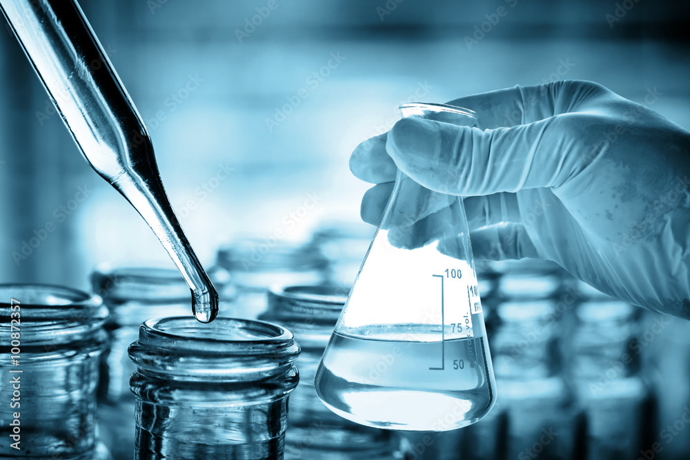 Wall mural flask in scientist hand with lab background