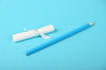 White paper scroll note and pencil on blue background