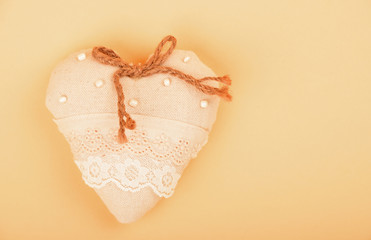Beige toy textile lace heart with bow with copy space