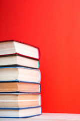 Open hardback book on wooden deck table and red background