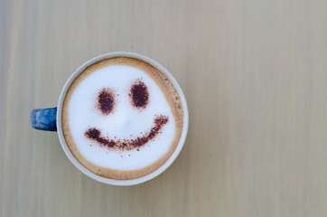 hot coffee with foam milk art smile pattern