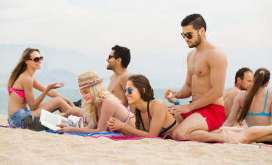 Friends relaxing at sandy beach