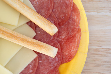 Provolone cheese slices and genoa salami plus breadsticks
