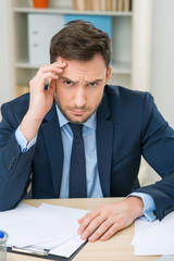 Emotional office worker sitting at the table 