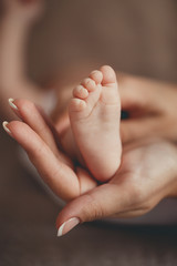 Children's legs on a mother's palm