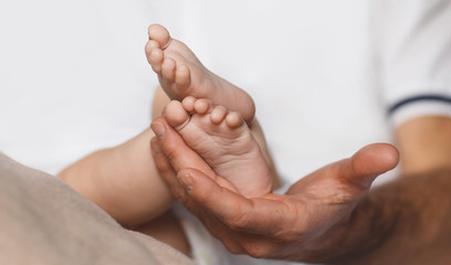 Children's legs on a mother's palm