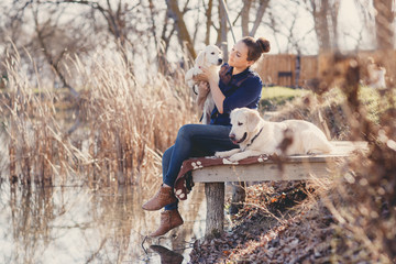 Fototapeta premium Beautiful girl with pets near the lake