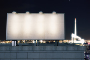 Big empty billboard on the background of the city at night, mock - obrazy, fototapety, plakaty