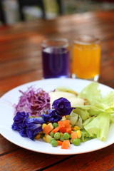 Healthy breakfast, fresh vegetable salad on wooden background.