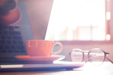Coffee cup with keyboard on wooden table