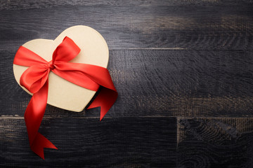 heart-shaped box with ribbon on the old wooden table