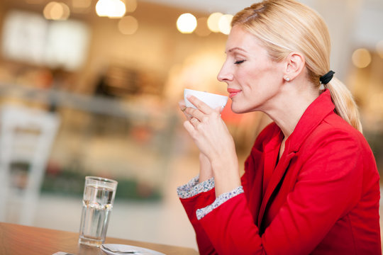 business middle-aged woman enjoying coffee in a cafe bar
