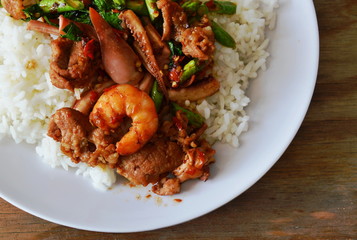 spicy stir-fried seafood with basil leaf on plain rice