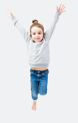 Active jumping girl in a gray sweater on a neutral background