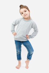 Obraz premium Girl child barefoot in jeans and a gray sweater without image. Imitates adult models For your design available space. other clothing for children and adults in my portfolio. gray background