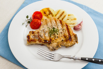 Juicy grilled pork chop with onion rings