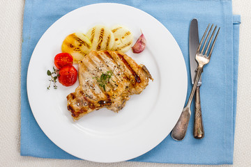 Juicy grilled pork chop, onion rings