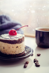 Sweet cake with a cherry and cup of coffee
