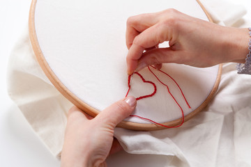Woman sewing a Red Heart Shaped Decoration