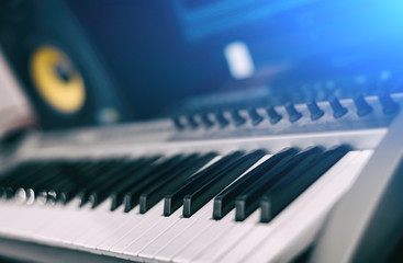 Midi keyboard. Home recording studio with professional monitors.
