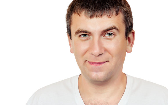 Smiling man with a raised eyebrow on a white background