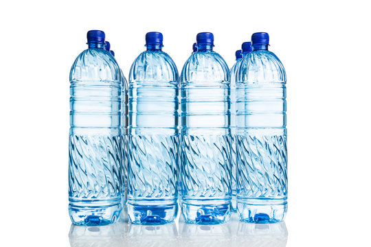 Rows of refreshing natural mineral water in plastic bottle in white background