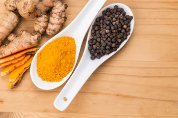 Fototapete Rund Turmeric roots and black pepper combination enhances bioavailability of curcumin absorption in body for health benefits © ThamKC