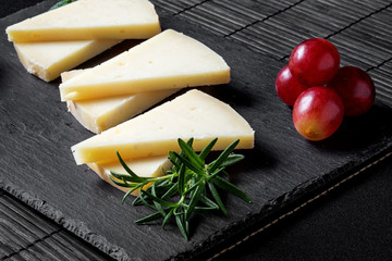 Close-up of sliced white cheese, cherry tomatoes and grape