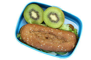 Healthy school lunch box containing brown bread sandwich and kiwi fruit isolated on white
