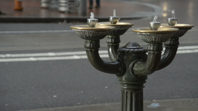 Benson Bubbler Water Fountain in Portland, Oregon with a street and people walking in the background.