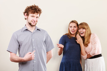 Two women talking gossiping about man.