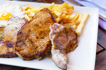 Grilled steaks, French fries, fried egg
