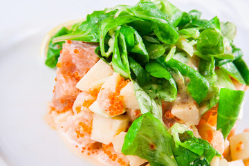 Salad with seafood and spinach on white plate