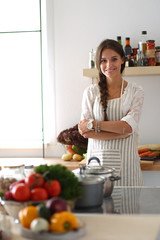 Young woman standing near desk in the kitchen